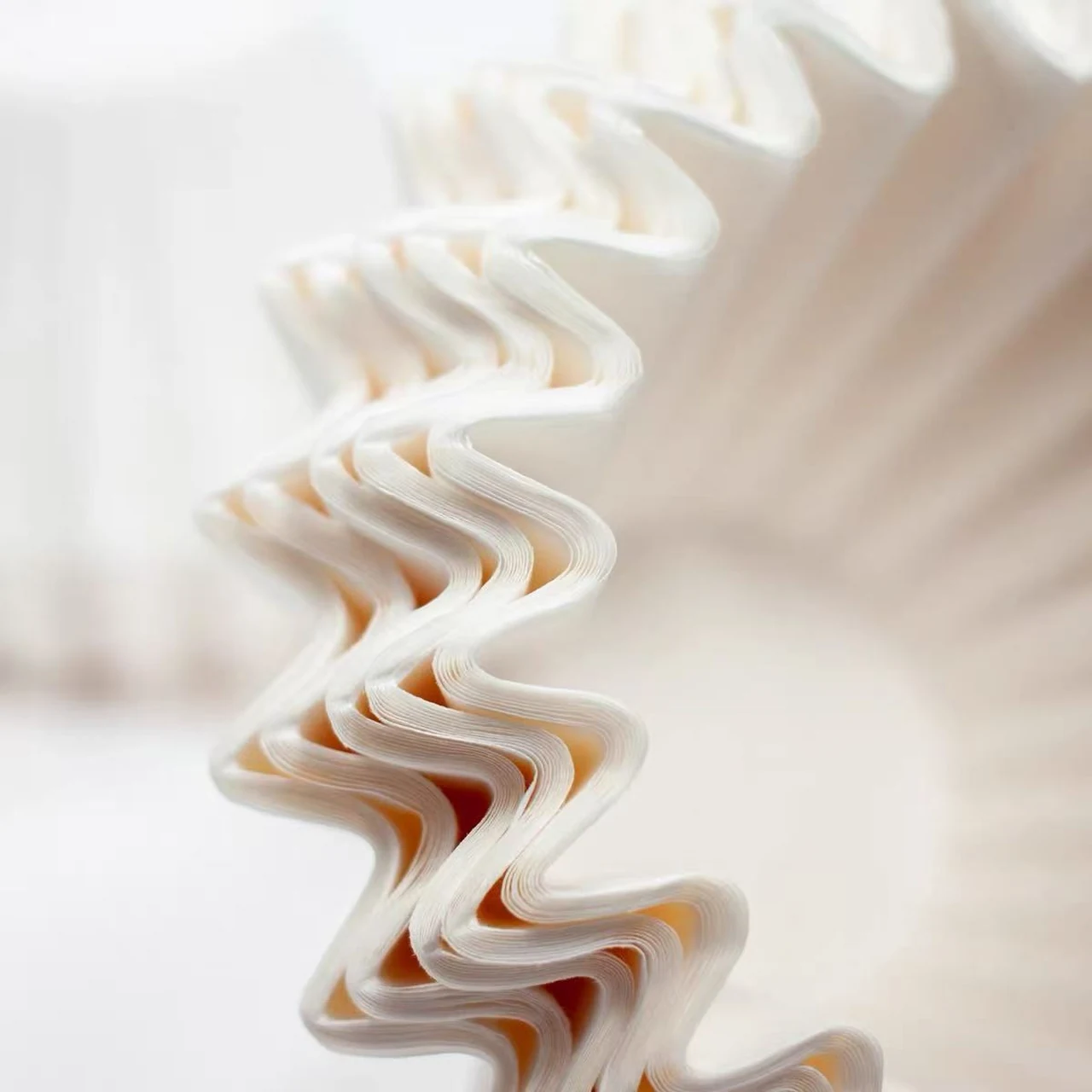 Pleated edges of white basket coffee filters.
